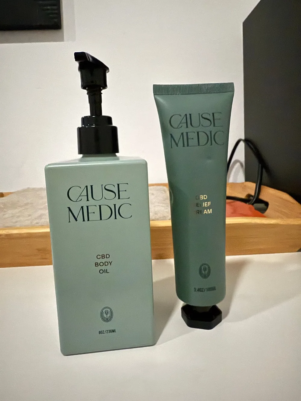 Cause Medic CBD body oil bottle and relief cream tube on a shelf in the studio